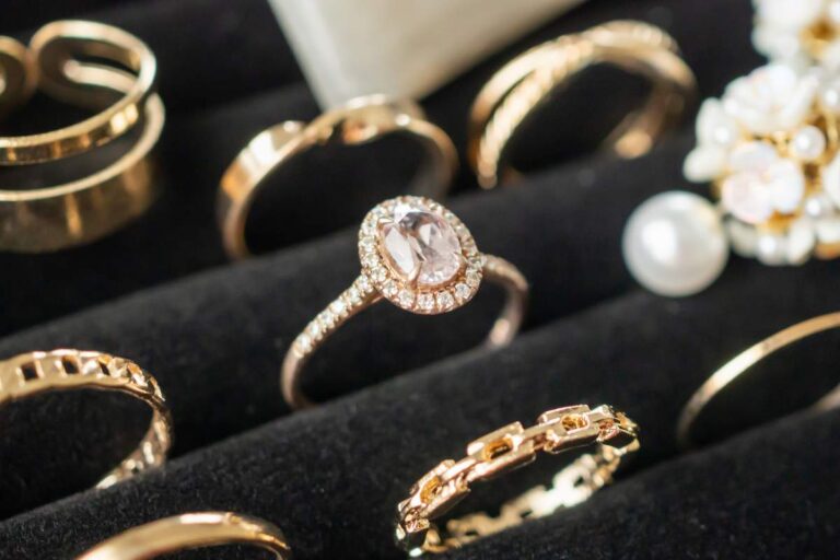A hand trying on an elegant diamond engagement ring in a natural-light setting.